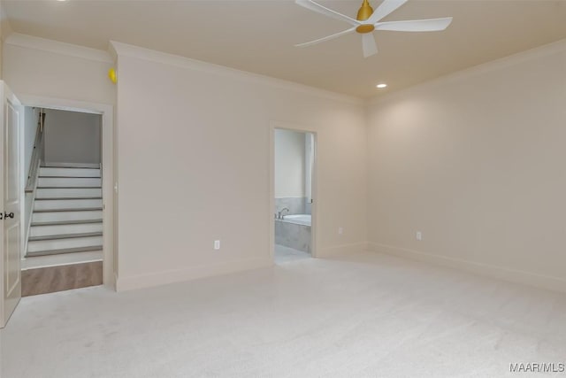 empty room featuring ornamental molding, light colored carpet, and ceiling fan