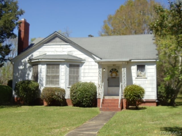 bungalow-style house featuring a front lawn