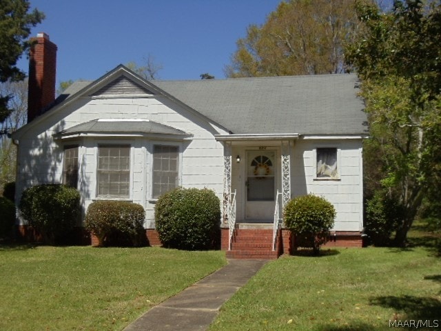 bungalow-style house featuring a front lawn