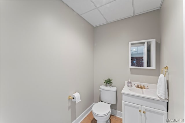 bathroom featuring toilet, a paneled ceiling, vanity, and tile patterned floors