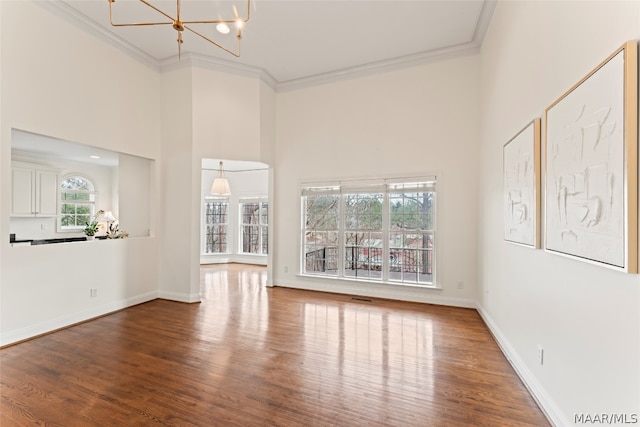 unfurnished living room featuring crown molding, a wealth of natural light, and hardwood / wood-style floors