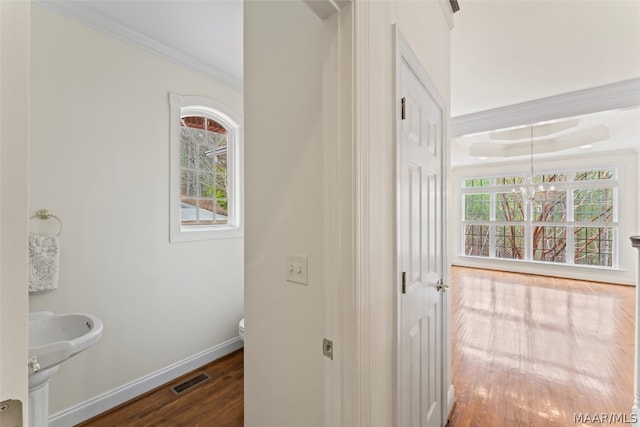 bathroom with toilet, crown molding, wood-type flooring, and a healthy amount of sunlight