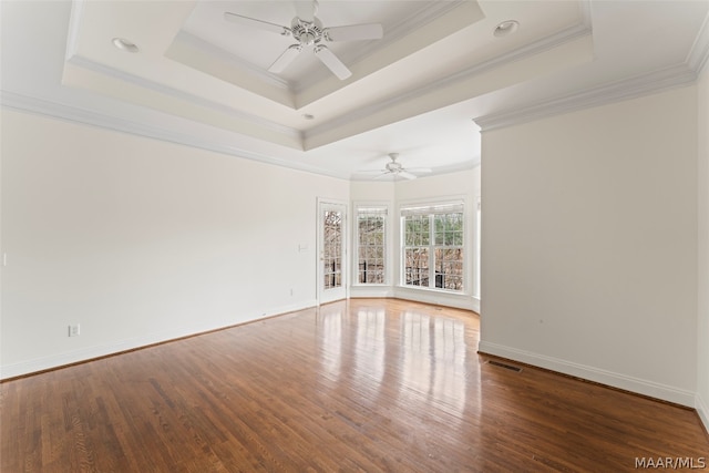 spare room with ornamental molding, hardwood / wood-style floors, and a tray ceiling