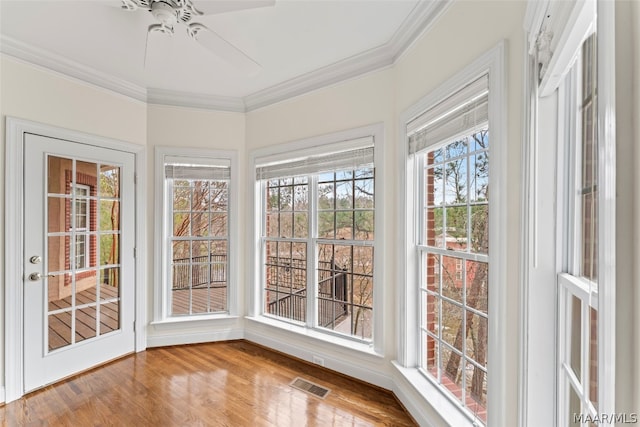 unfurnished sunroom with ceiling fan