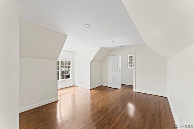 bonus room featuring vaulted ceiling and dark hardwood / wood-style flooring