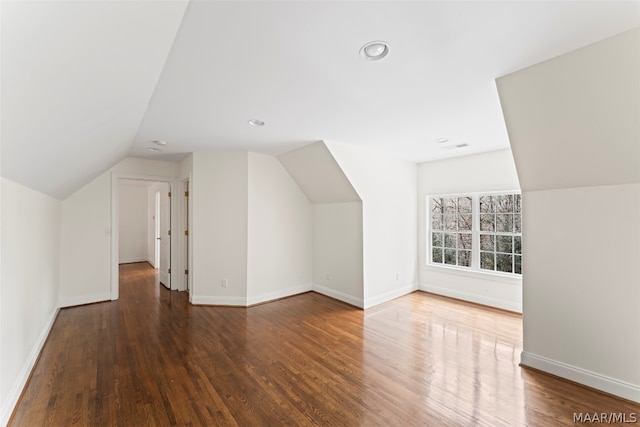 additional living space featuring hardwood / wood-style flooring and vaulted ceiling