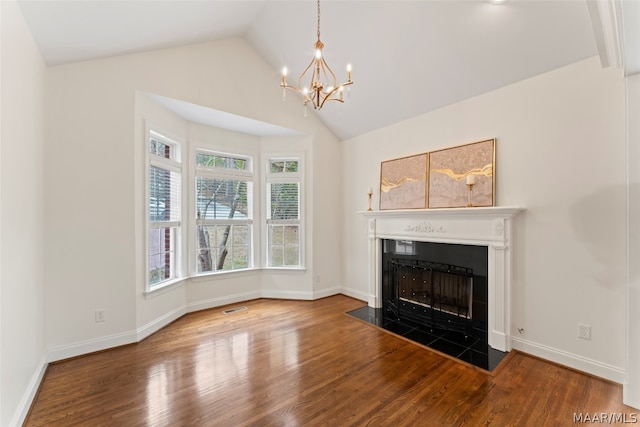 unfurnished living room with lofted ceiling, an inviting chandelier, and hardwood / wood-style floors