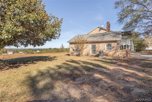 rear view of property featuring a lawn