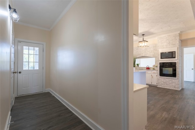 doorway featuring dark hardwood / wood-style flooring, crown molding, a fireplace, and a textured ceiling