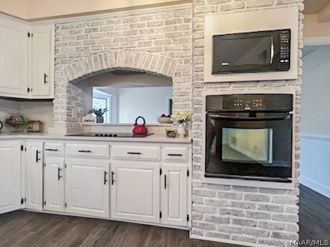 kitchen with white cabinets, dark wood-type flooring, and black appliances