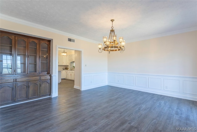 interior space featuring a textured ceiling, a chandelier, crown molding, and dark wood-type flooring