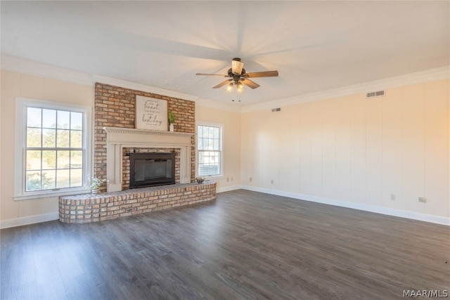 unfurnished living room with dark hardwood / wood-style floors, a brick fireplace, ornamental molding, and ceiling fan