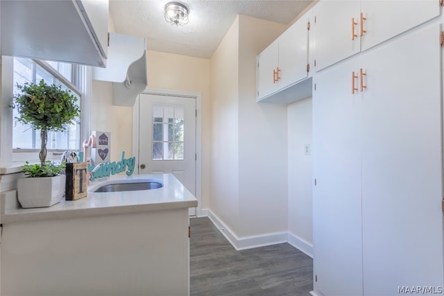 kitchen with white cabinets, a textured ceiling, dark wood-type flooring, and a healthy amount of sunlight