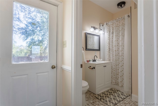 bathroom with toilet, tile floors, and vanity