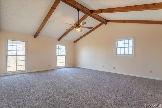 carpeted spare room featuring ceiling fan, a textured ceiling, beamed ceiling, and a healthy amount of sunlight