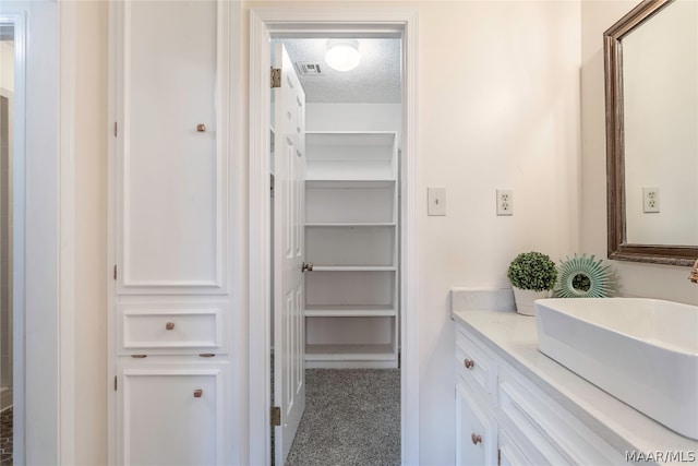 bathroom featuring a textured ceiling and vanity