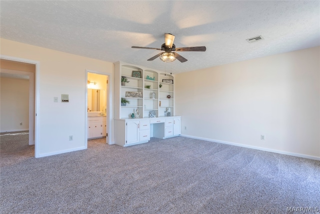 unfurnished bedroom with light colored carpet, ceiling fan, and a textured ceiling