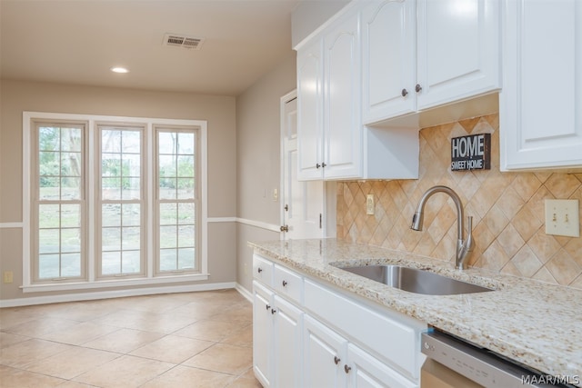 kitchen with white cabinetry, sink, light tile floors, light stone counters, and tasteful backsplash