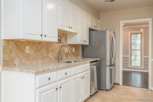 kitchen featuring appliances with stainless steel finishes, white cabinetry, backsplash, and light hardwood / wood-style floors