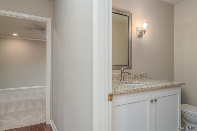 bathroom featuring ceiling fan, toilet, and vanity