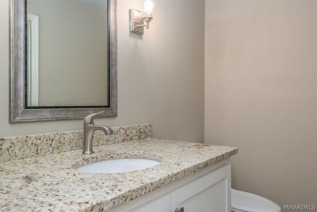 bathroom featuring toilet and vanity with extensive cabinet space