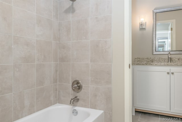 bathroom with tiled shower / bath combo, vanity, and tile flooring