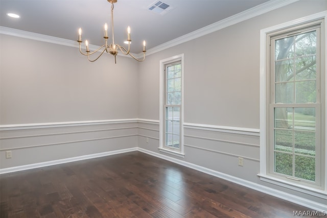 spare room featuring an inviting chandelier, crown molding, and dark wood-type flooring