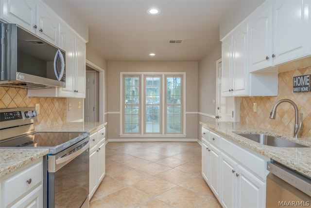 kitchen with light stone countertops, backsplash, sink, and stainless steel appliances