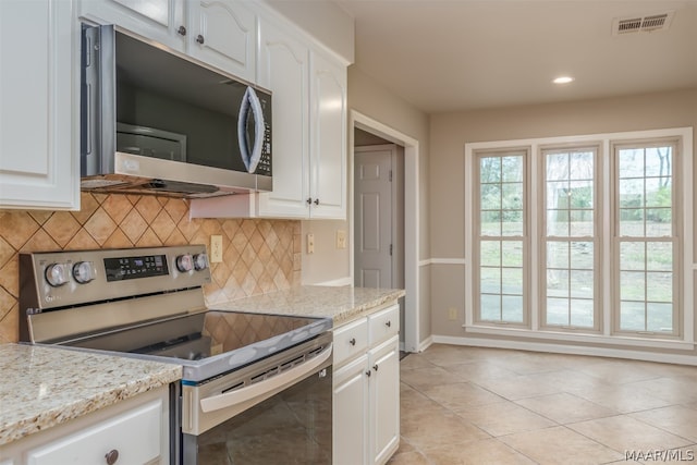 kitchen featuring white cabinets, tasteful backsplash, light stone countertops, and stainless steel appliances