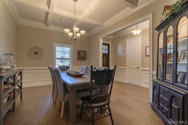 dining room with coffered ceiling, hardwood / wood-style flooring, beam ceiling, ornamental molding, and an inviting chandelier