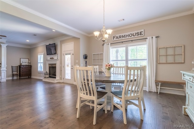 dining room featuring crown molding, dark wood-type flooring, ornate columns, and a chandelier