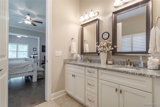 bathroom featuring large vanity, ceiling fan, ornamental molding, tile flooring, and dual sinks