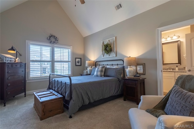 carpeted bedroom with ceiling fan, high vaulted ceiling, sink, and ensuite bath