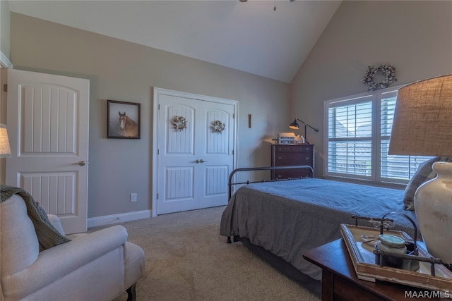 bedroom featuring a closet, light colored carpet, and high vaulted ceiling