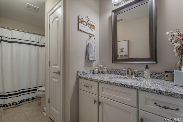 bathroom featuring tile floors, toilet, and vanity