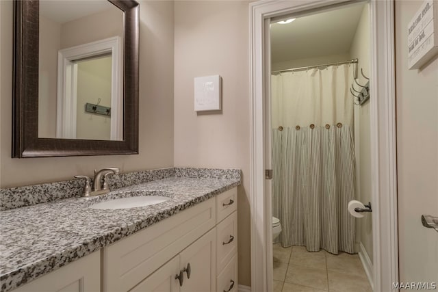 bathroom featuring tile flooring, toilet, and large vanity