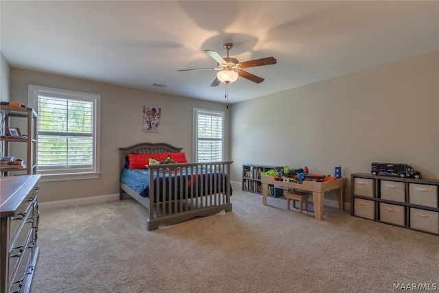 bedroom with ceiling fan, light carpet, and multiple windows