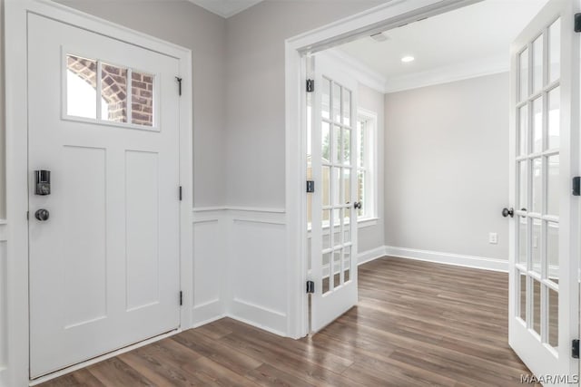 entrance foyer with ornamental molding, dark wood-type flooring, and french doors