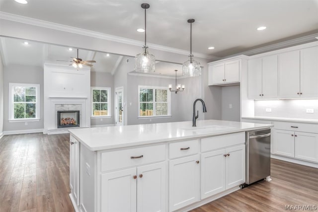 kitchen featuring stainless steel dishwasher, a kitchen island with sink, white cabinetry, and sink