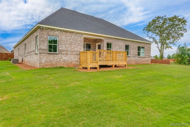 back of property with cooling unit, a yard, and a wooden deck