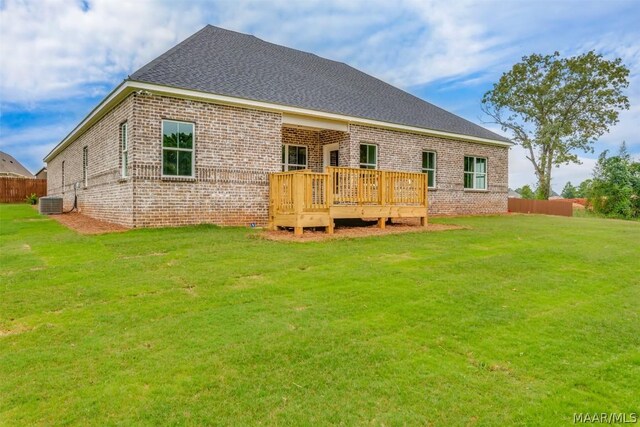 back of property with cooling unit, a yard, and a wooden deck