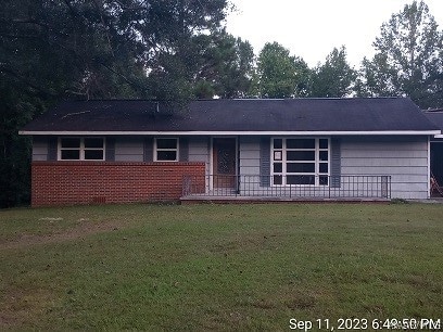 ranch-style home with a front lawn