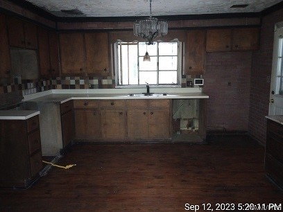 kitchen featuring an inviting chandelier, sink, and dark hardwood / wood-style flooring