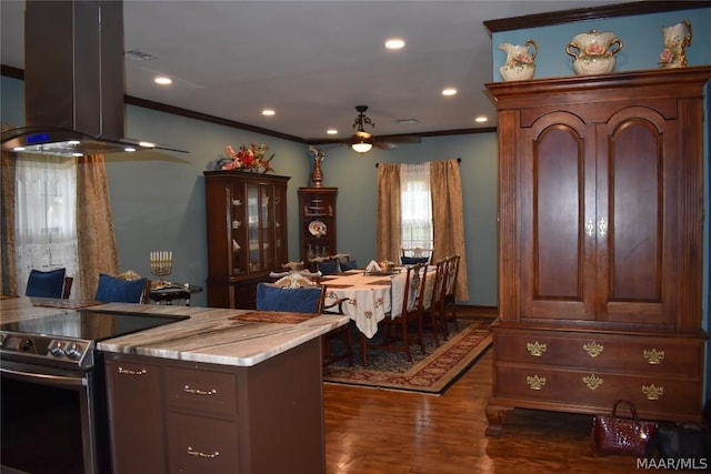 kitchen featuring island exhaust hood, dark hardwood / wood-style floors, ornamental molding, and stainless steel electric range