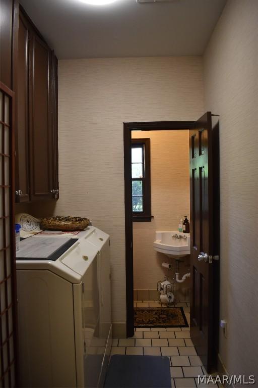 laundry area featuring cabinets, sink, and washing machine and clothes dryer