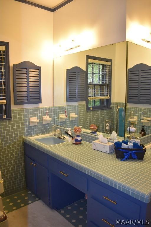 bathroom featuring vanity and tile walls