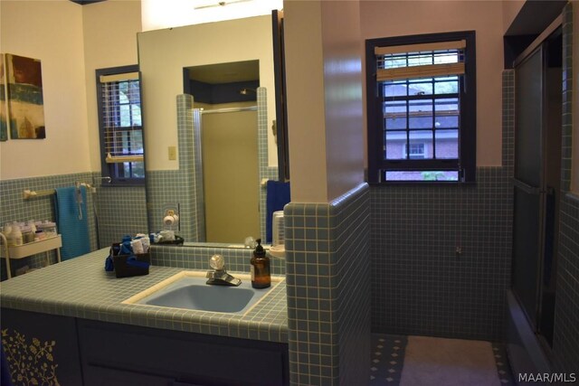 bathroom featuring vanity, tile walls, and walk in shower