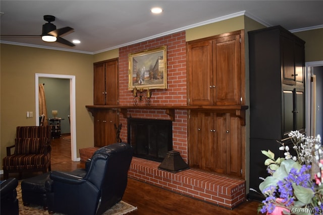 living room with ceiling fan, a fireplace, crown molding, and dark wood-type flooring