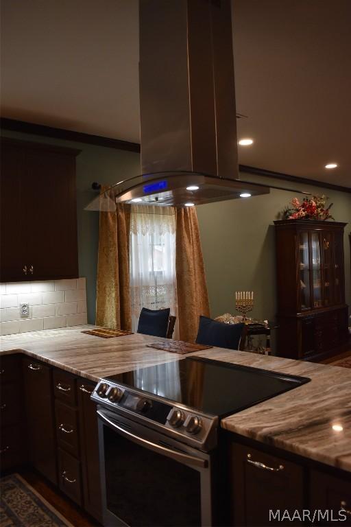 kitchen featuring tasteful backsplash, dark brown cabinetry, stainless steel electric range oven, and island range hood