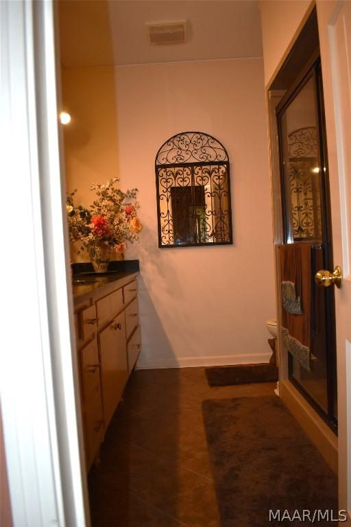 bathroom featuring tile patterned flooring, vanity, and walk in shower